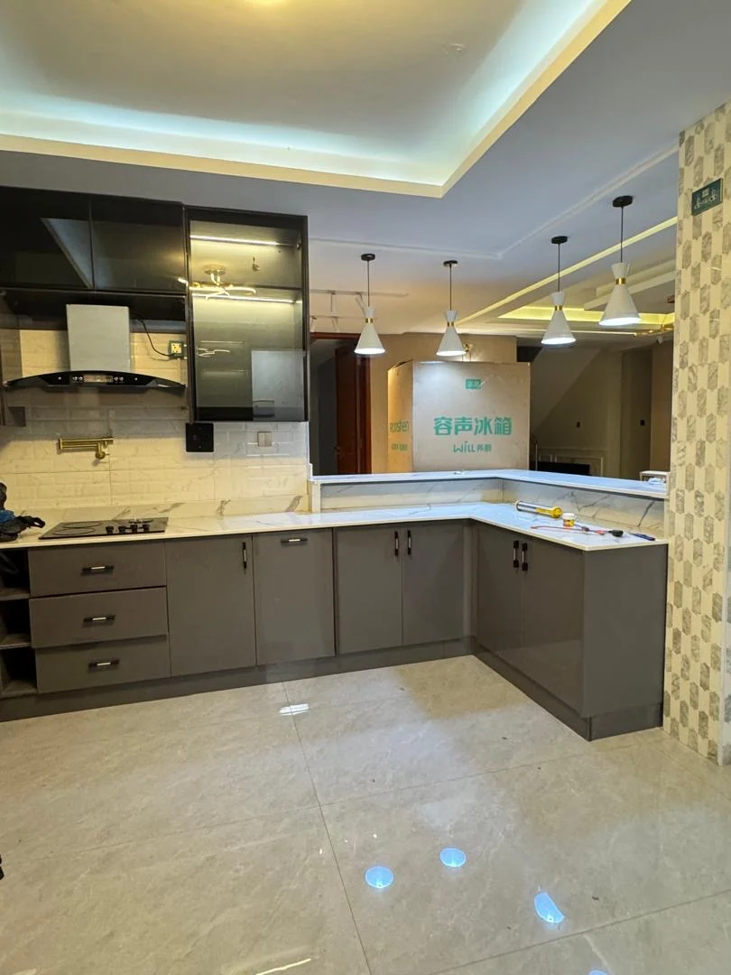 Fitted kitchen cabinetry, a worktop and lighting in a kitchen interior.